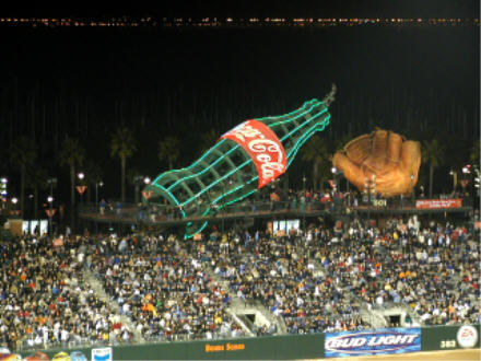 Giant Coke bottle and glove behind LF stands
